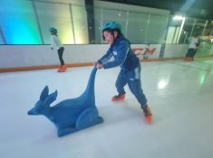 child ice skating with frame